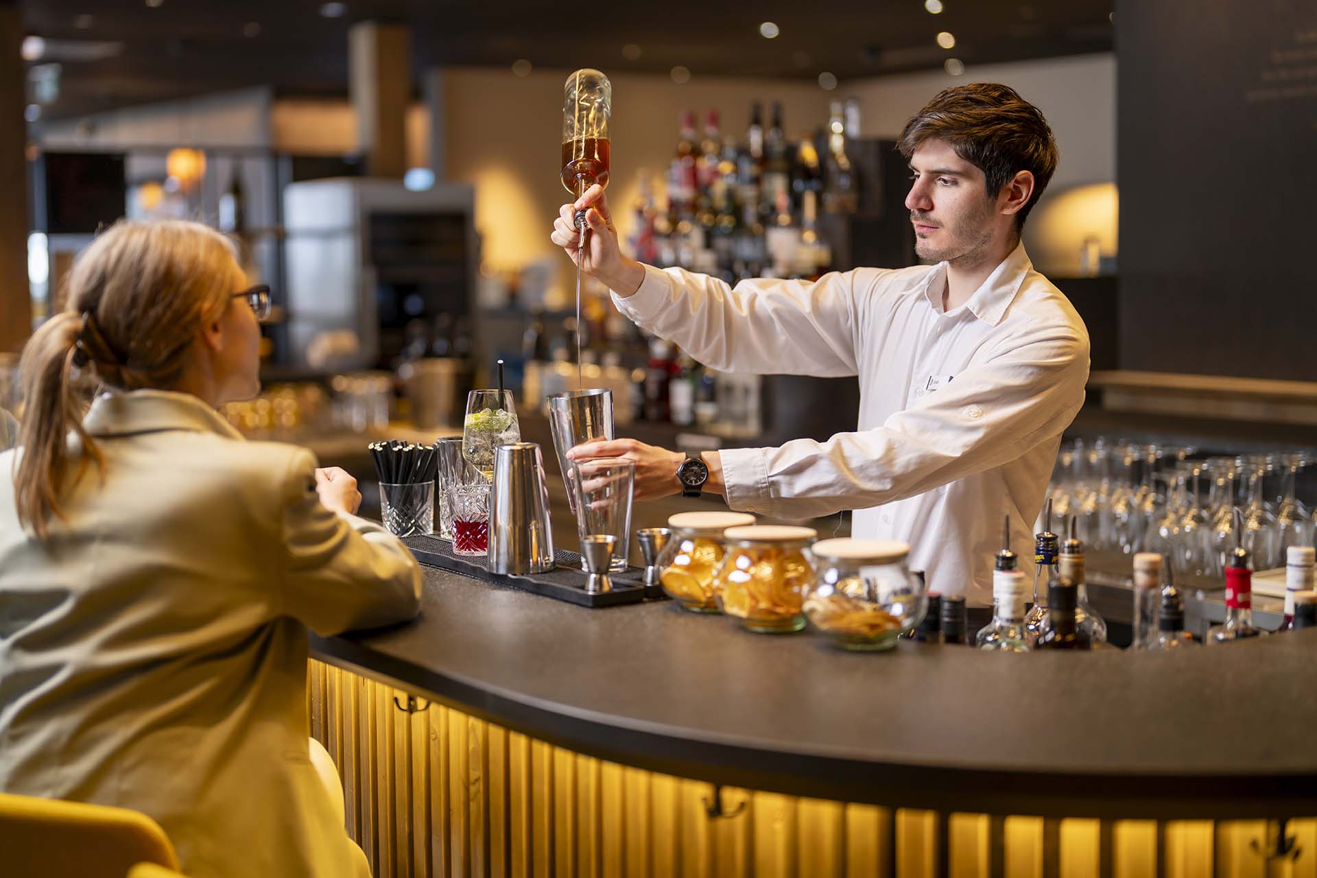Barkeeper bereitet Drink vor Gast an der Bar im Hotel Krone zu