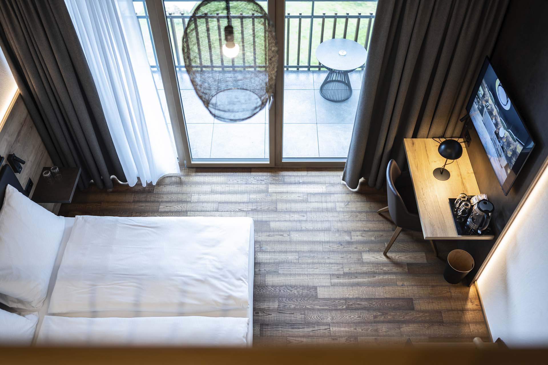 Maisonettezimmer mit Doppelbett und Balkon mit Ausblick ins Grüne im Hotel Krone
