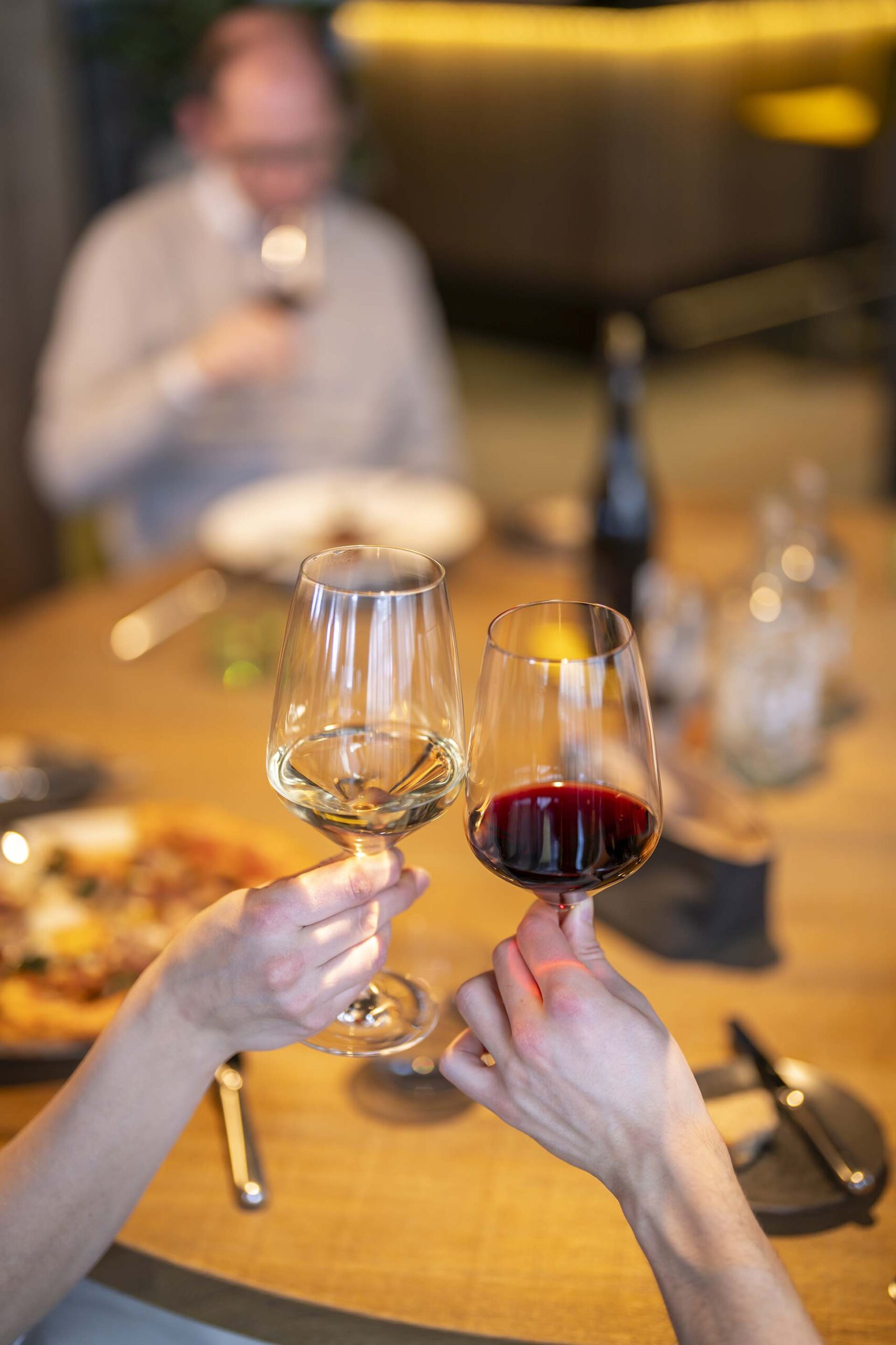 Zwei Freunde beim Anstoßen mit Wein im Restaurant im Hotel Krone
