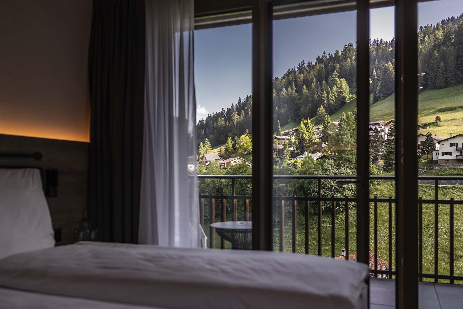 Hotelzimmer im Hotel Krone mit Bett und Aussicht auf Balkon im Sommer