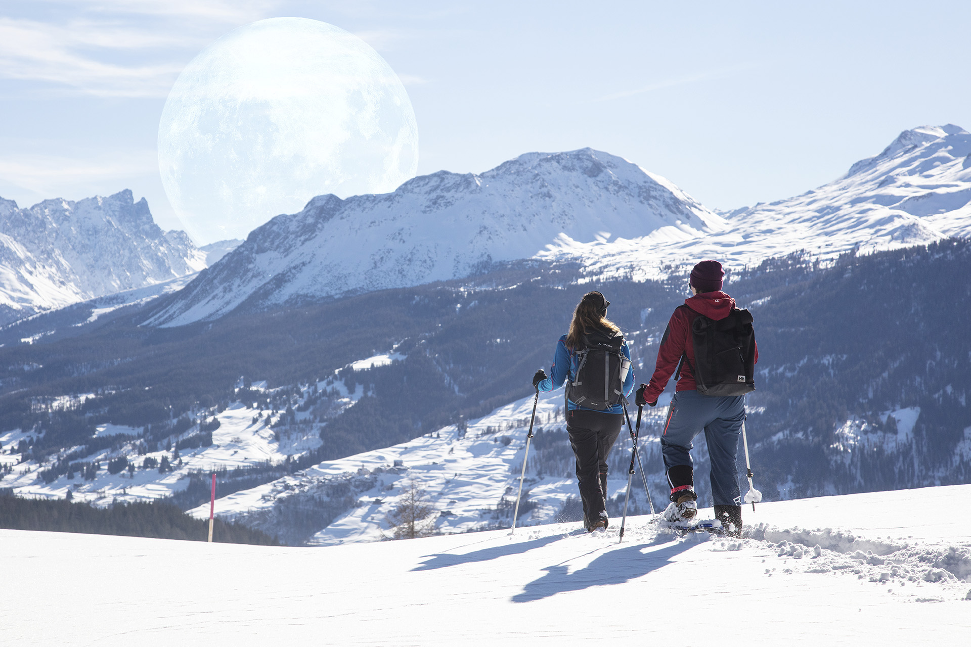 Mann und Frau machen eine Schneeschuhwanderung durch die Winterlandschaft in der Lenzerheide
