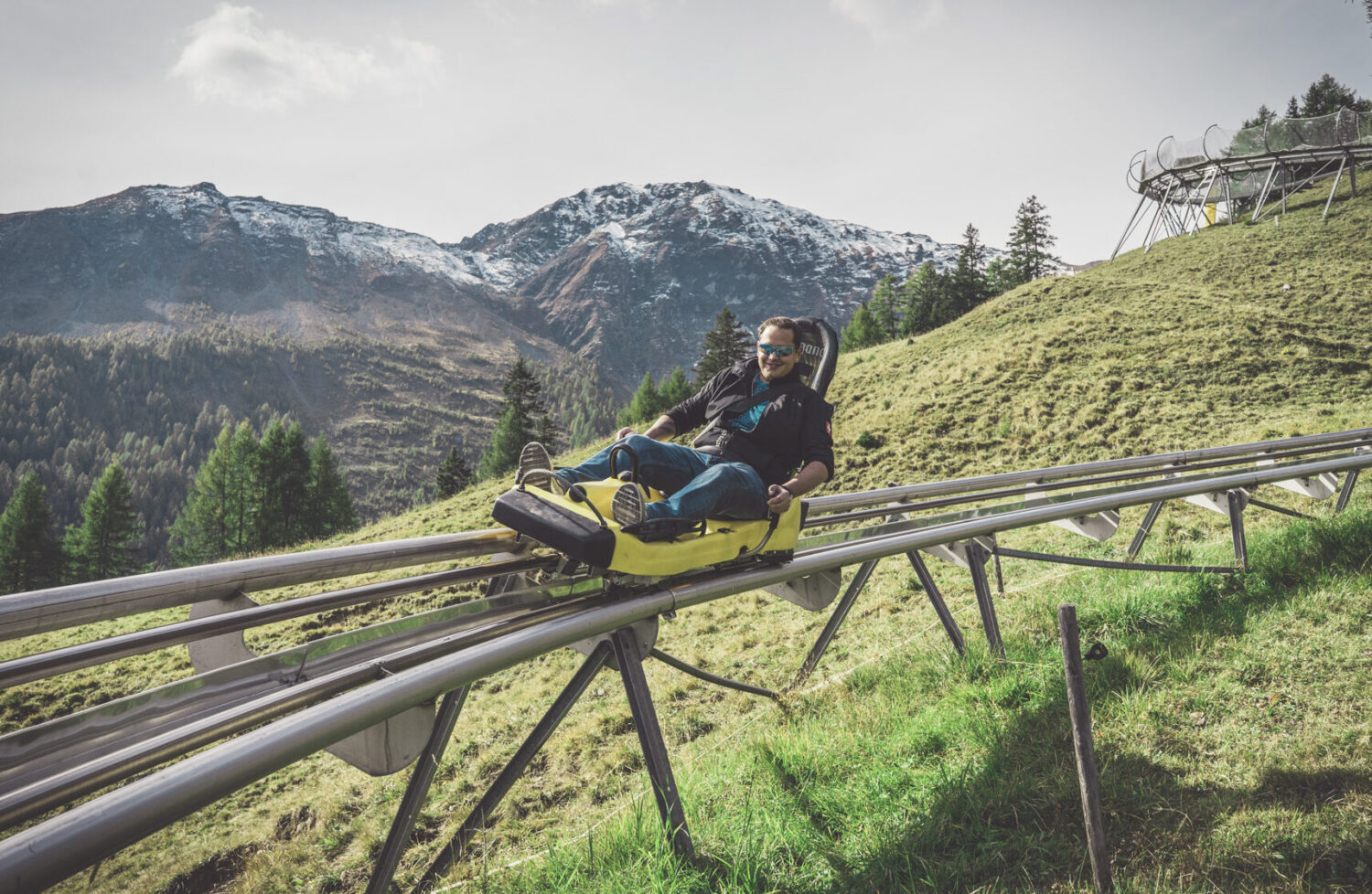 Mann fährt mit der Rodelbahn am Erlebnisberg Pradaschier in Churwalden