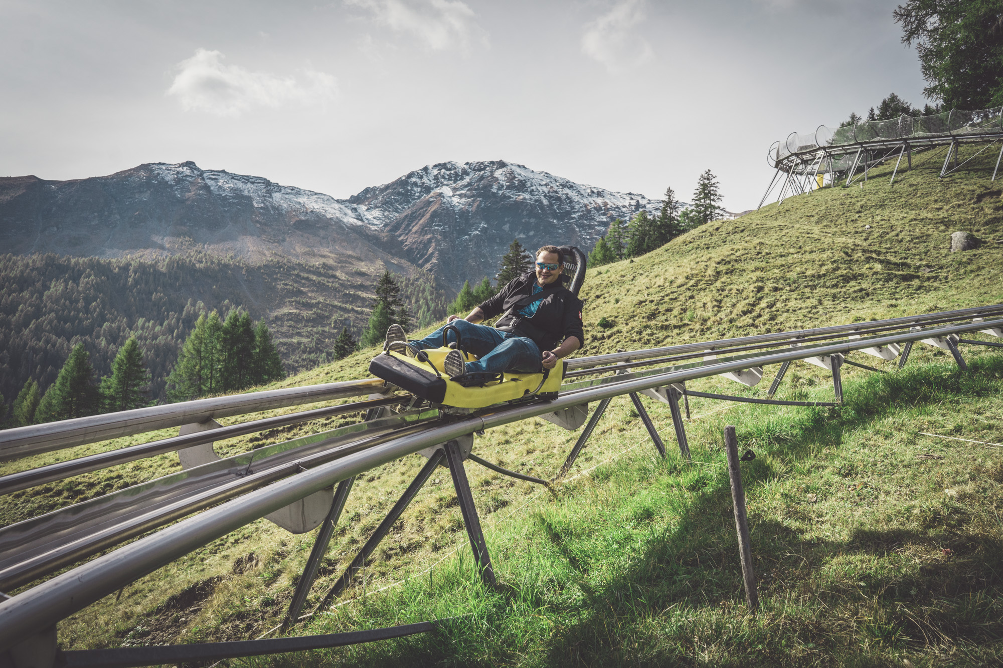 Mann fährt mit der Rodelbahn am Erlebnisberg Pradaschier in Churwalden