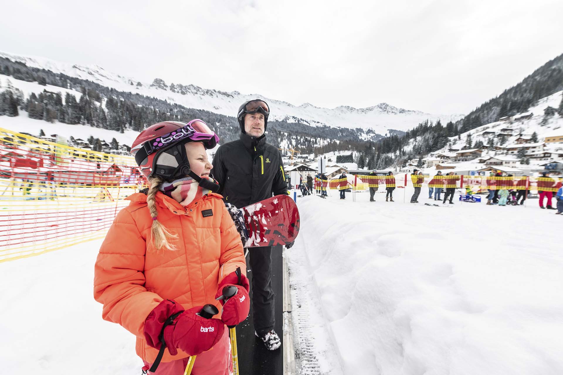 Kind und Mann in Skiausrüstung auf dem Zauberteppich in Pradaschier