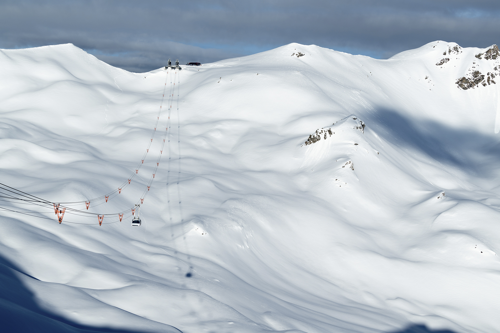 Seilbahn-Gondel schwebt über verschneite Berglandschaft in der Lenzerheide