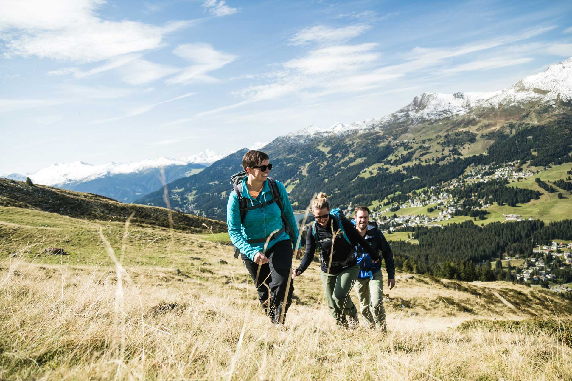 Gruppe von drei Freunden wandert durch die herbstliche Landschaft in der Lenzerheide